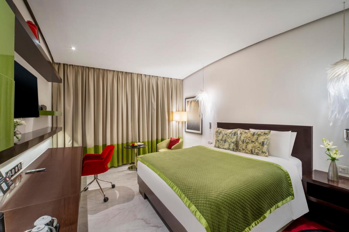 a hotel room with a green bed and a desk at The Park Chennai in Chennai