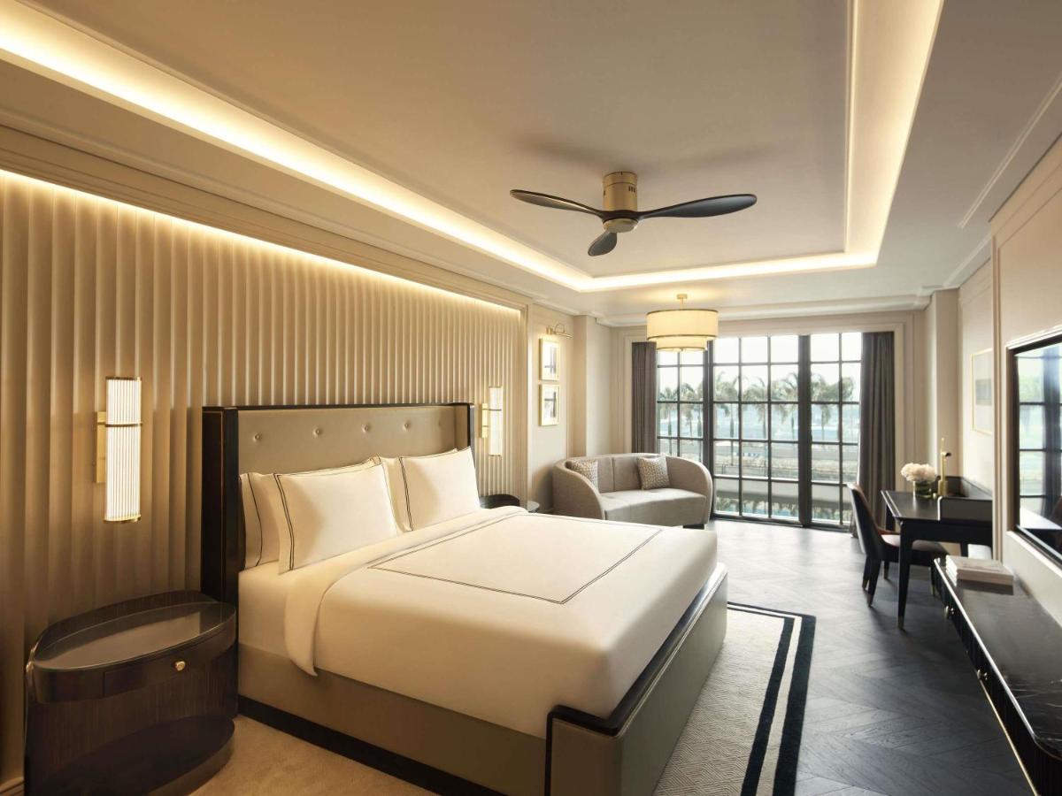 a bedroom with a bed and a couch and a desk at Fairmont Mumbai in Mumbai