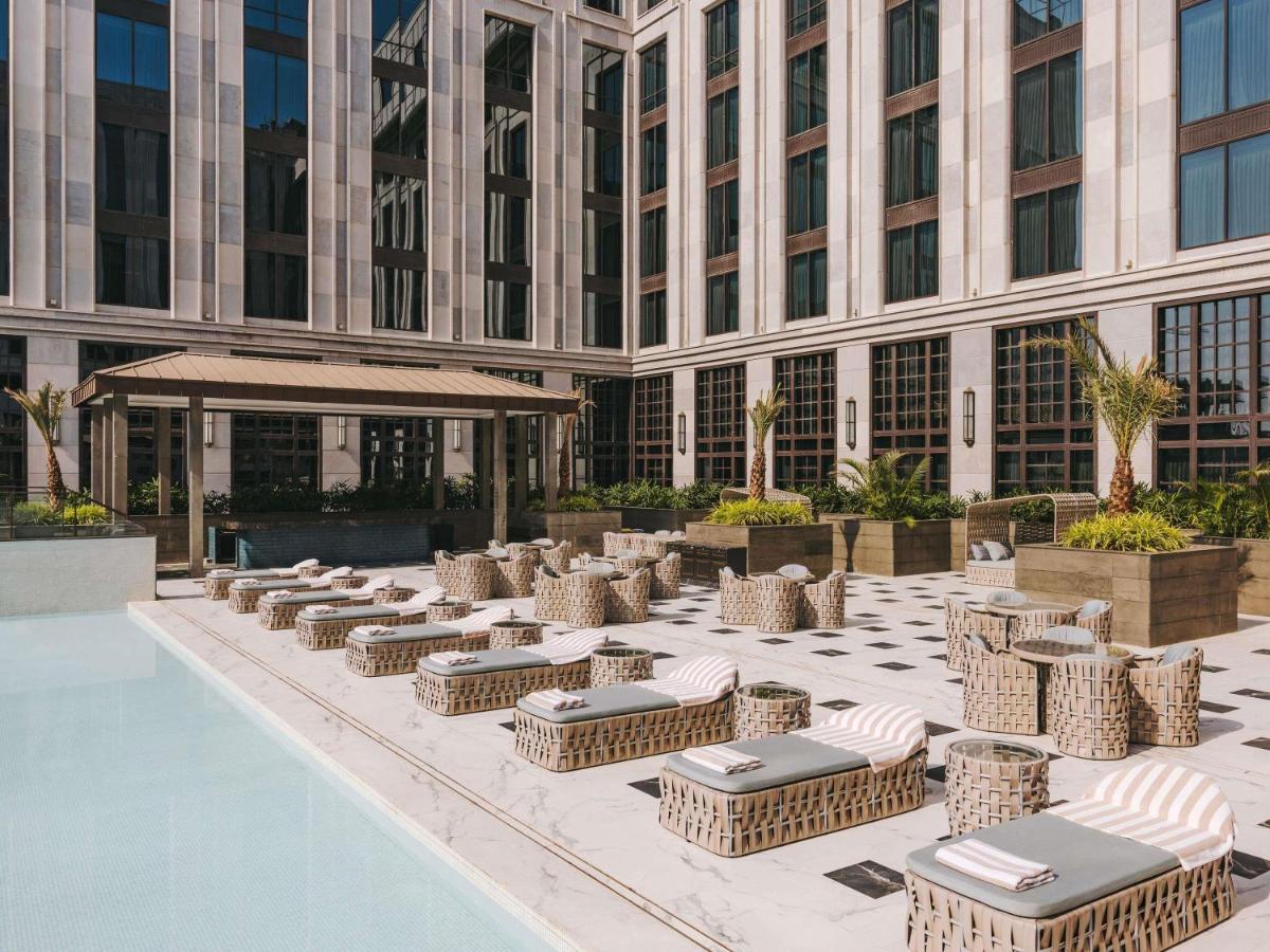 a building with a bunch of wicker chairs and a pool at Fairmont Mumbai in Mumbai