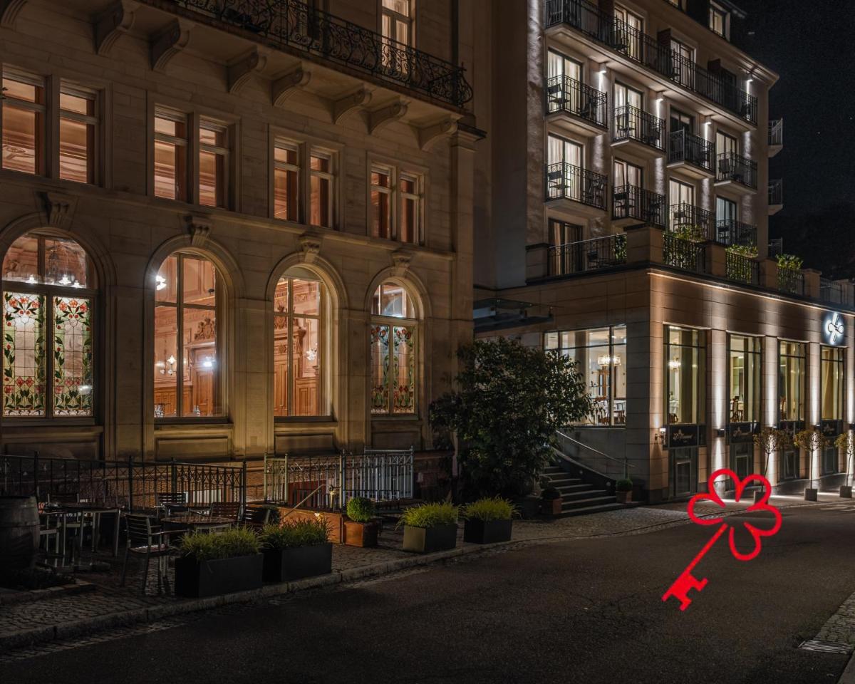 ein großes Gebäude mit einer roten Schleife davor in der Unterkunft Maison Messmer - ein Mitglied der Hommage Luxury Hotels Collection in Baden-Baden