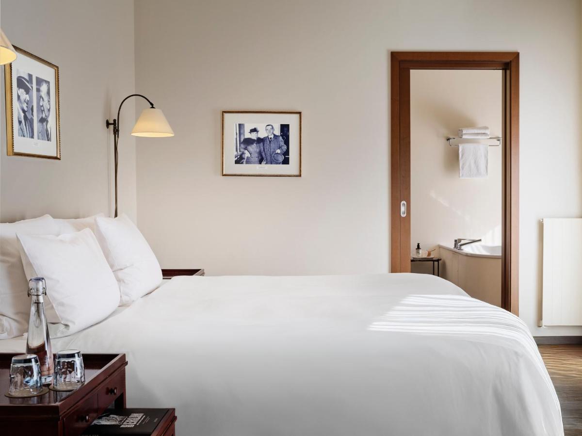 ein Schlafzimmer mit einem großen weißen Bett und ein Badezimmer in der Unterkunft ABION Villa Suites in Berlin + 29 Fotos