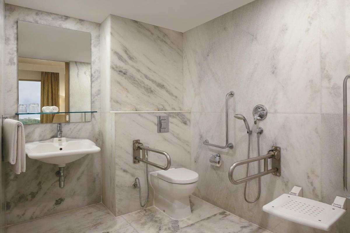 a bathroom with a shower toilet and a sink at Four Points by Sheraton Hotel and Serviced Apartments Pune in Pune