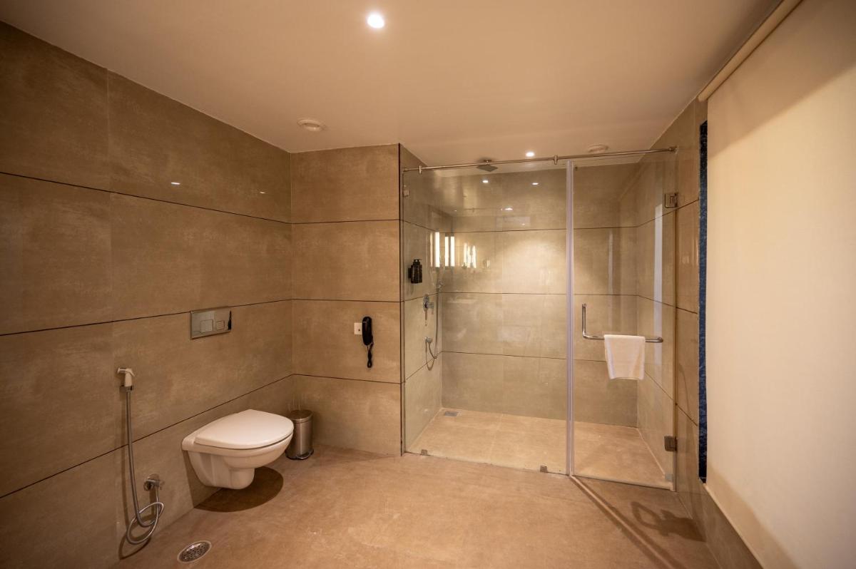 a bathroom with a shower and a toilet at Essentia Luxury Resort & Spa Udaipur in Udaipur