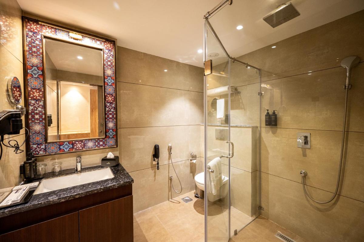 a bathroom with a shower and a sink and a toilet at Essentia Luxury Resort & Spa Udaipur in Udaipur