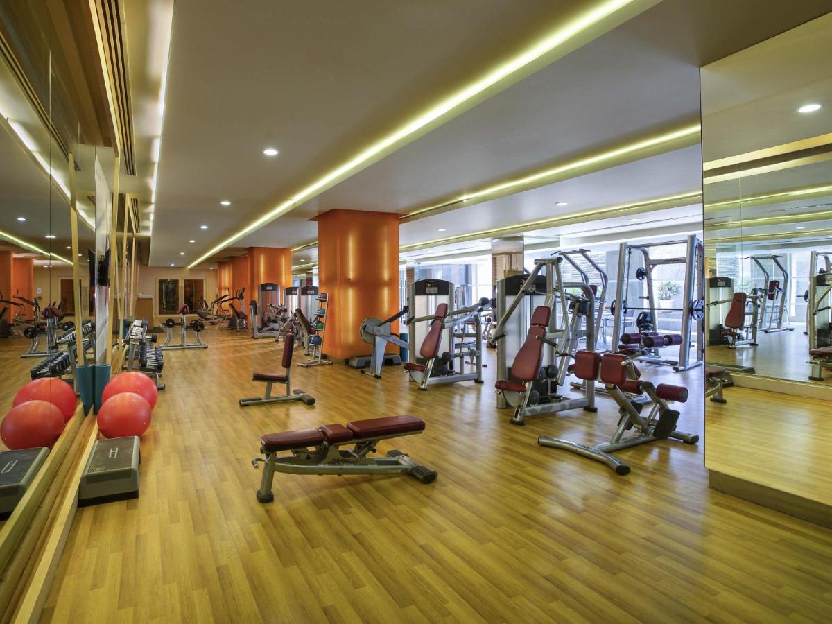 a gym with treadmills and exercise equipment in a building at Novotel Hyderabad Airport in Hyderabad