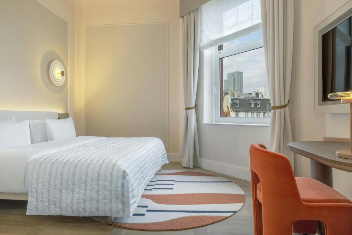 ein Schlafzimmer mit Bett, Schreibtisch und Fenster in der Unterkunft Le Méridien Frankfurt in Frankfurt am Main