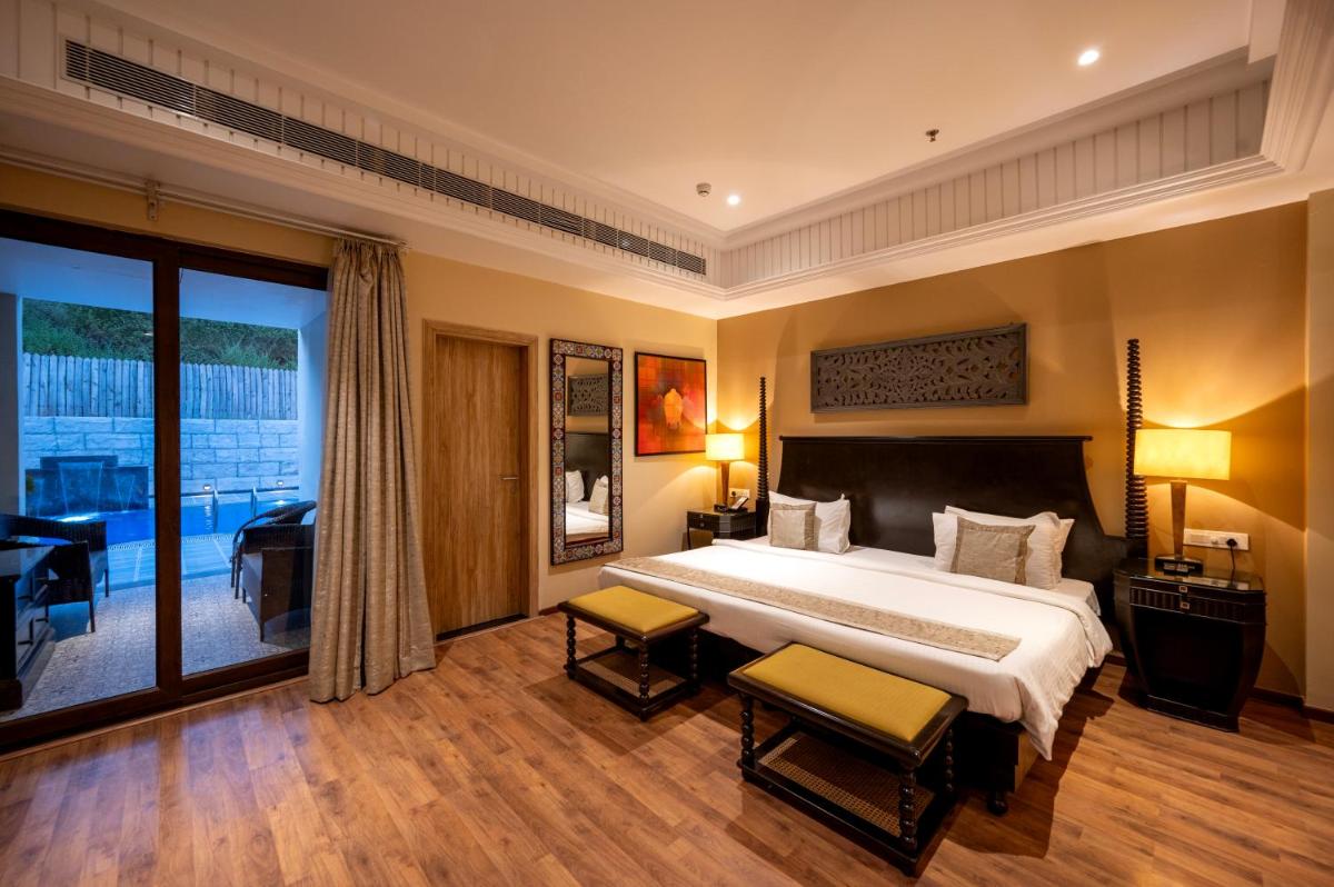 a bedroom with a large bed and a balcony at Essentia Luxury Resort & Spa Udaipur in Udaipur
