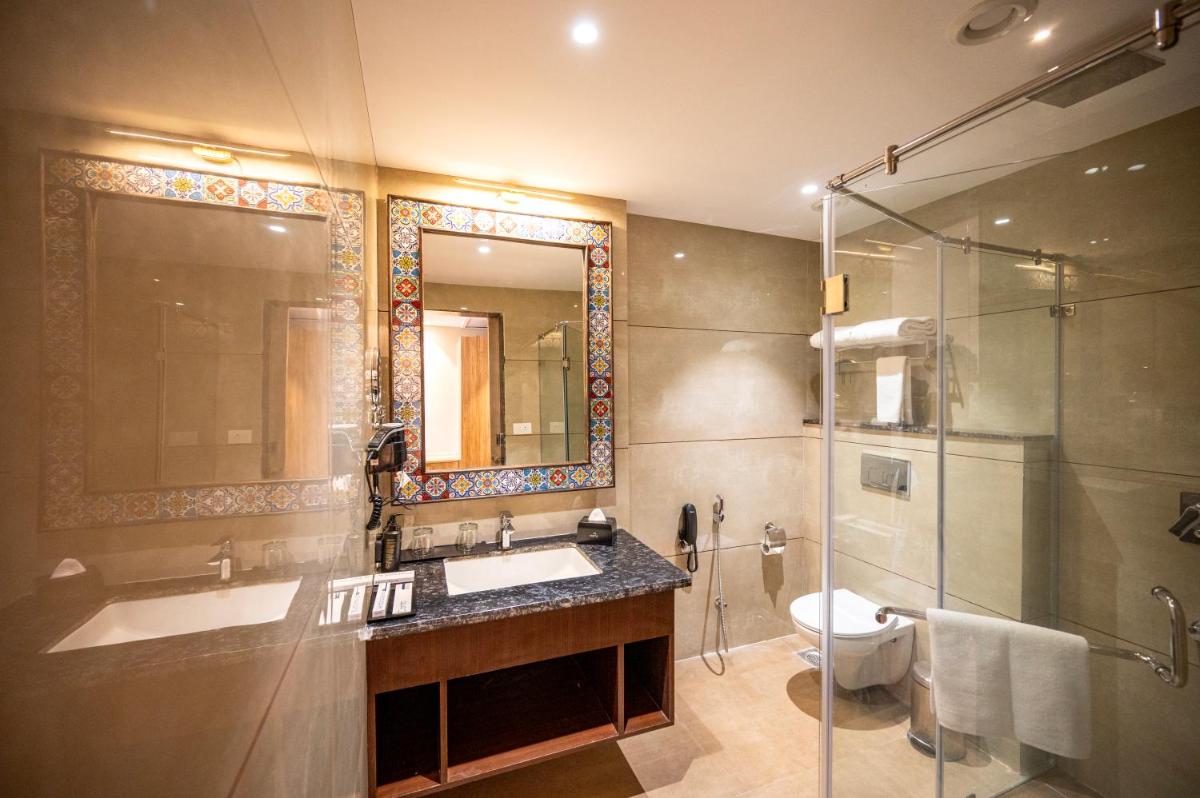 a bathroom with a sink and a shower and a toilet at Essentia Luxury Resort & Spa Udaipur in Udaipur