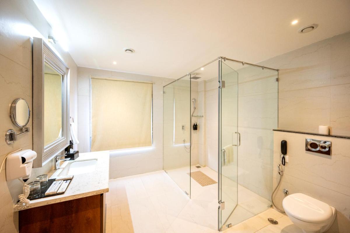 a bathroom with a glass shower and a toilet at Essentia Luxury Resort & Spa Udaipur in Udaipur