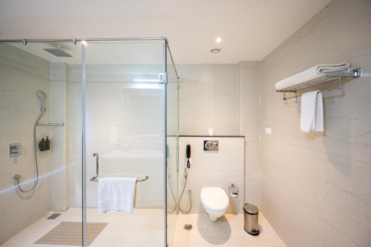 a bathroom with a glass shower and a toilet at Essentia Luxury Resort & Spa Udaipur in Udaipur