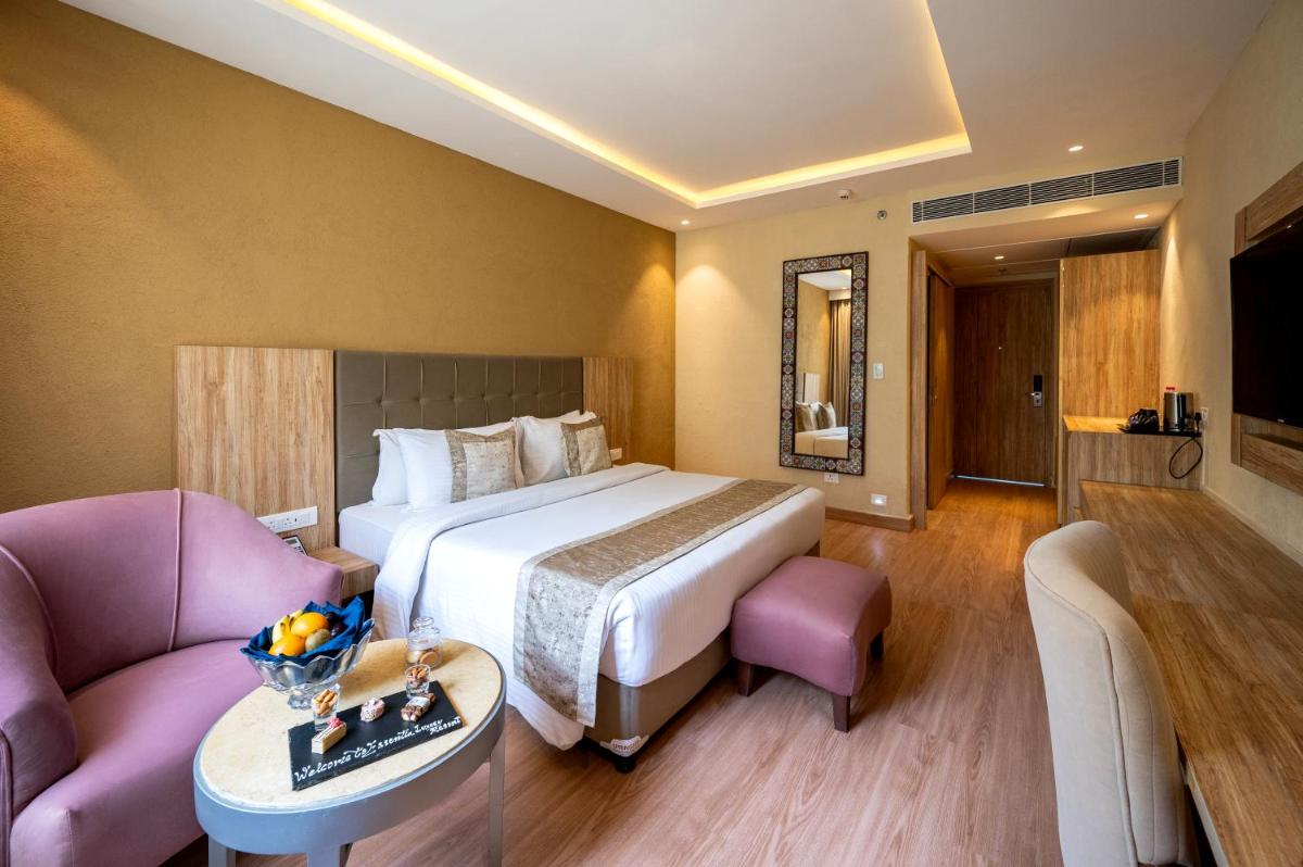 a hotel room with a bed and a couch at Essentia Luxury Resort & Spa Udaipur in Udaipur
