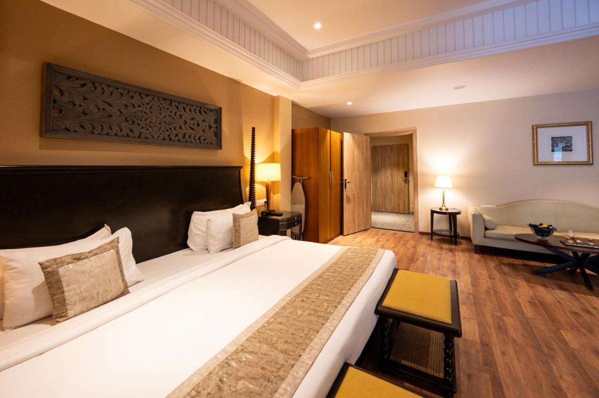 a hotel room with a large bed and a couch at Essentia Luxury Resort & Spa Udaipur in Udaipur