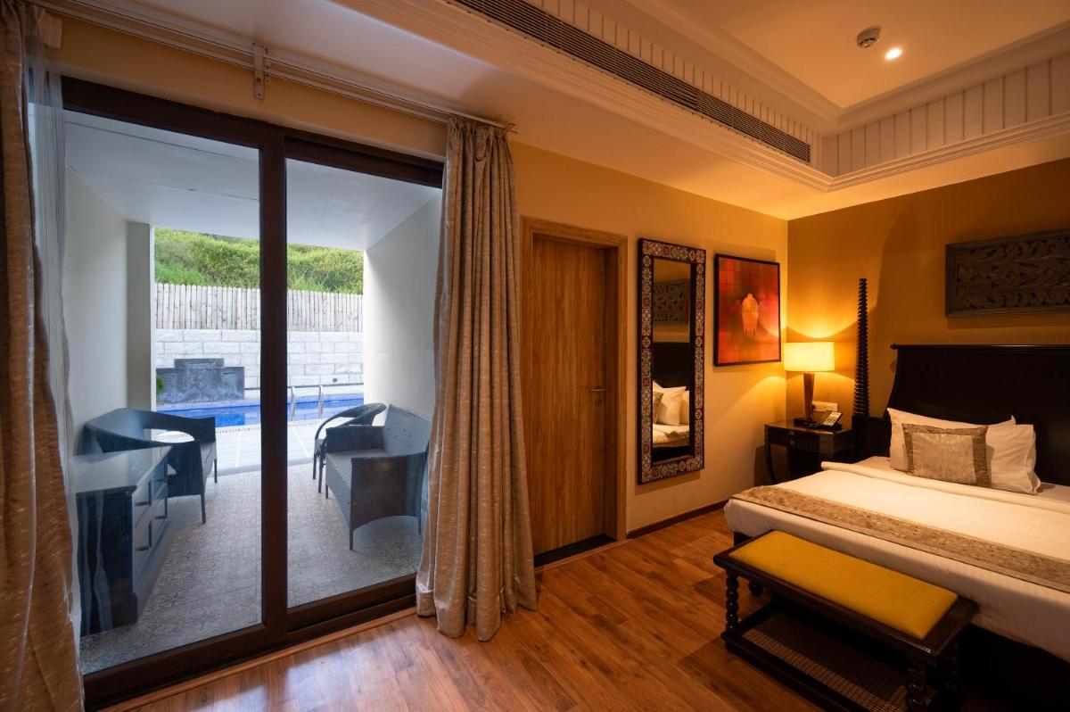 a hotel room with a bed and a balcony at Essentia Luxury Resort & Spa Udaipur in Udaipur