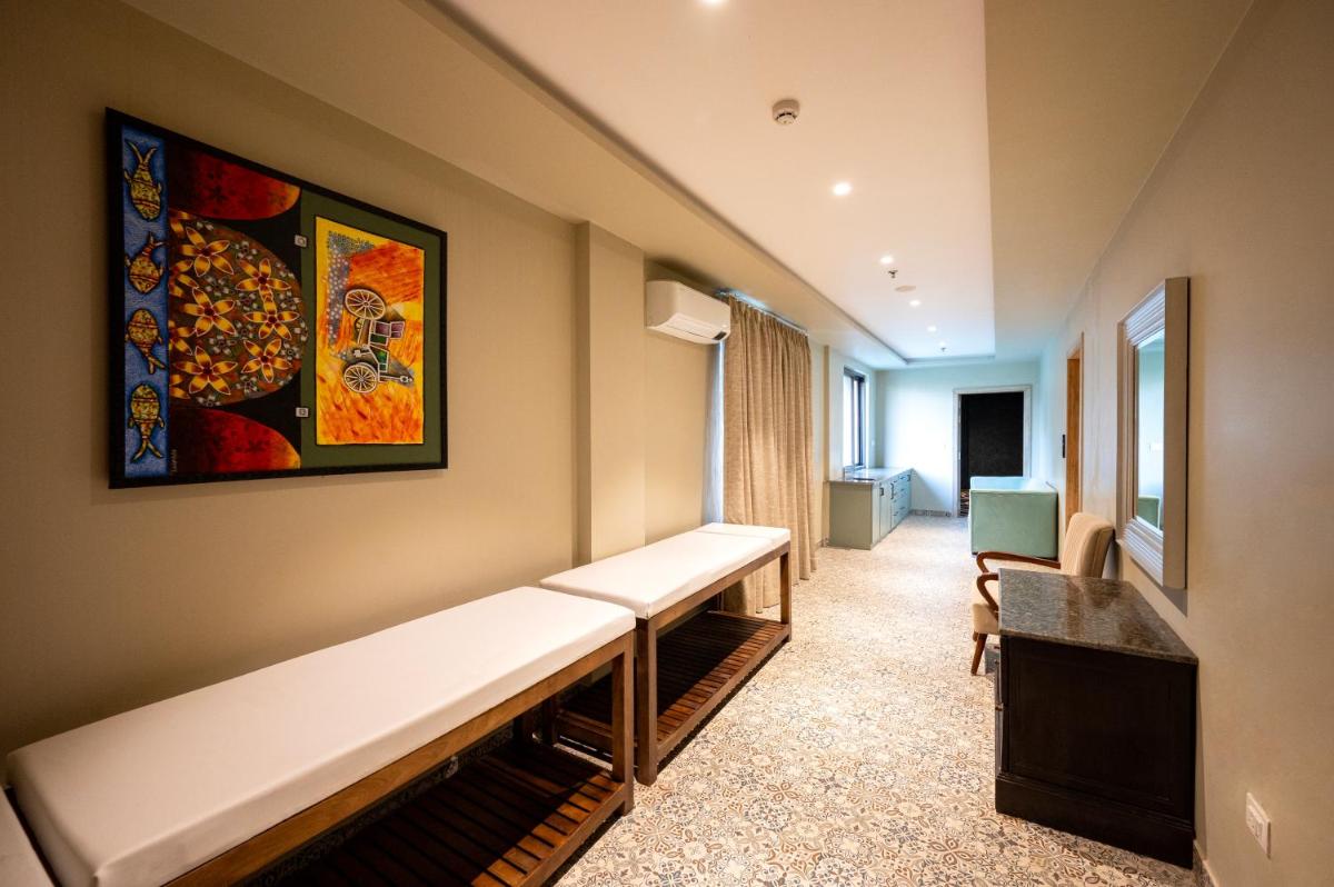 a hospital room with a bench and a painting on the wall at Essentia Luxury Resort & Spa Udaipur in Udaipur