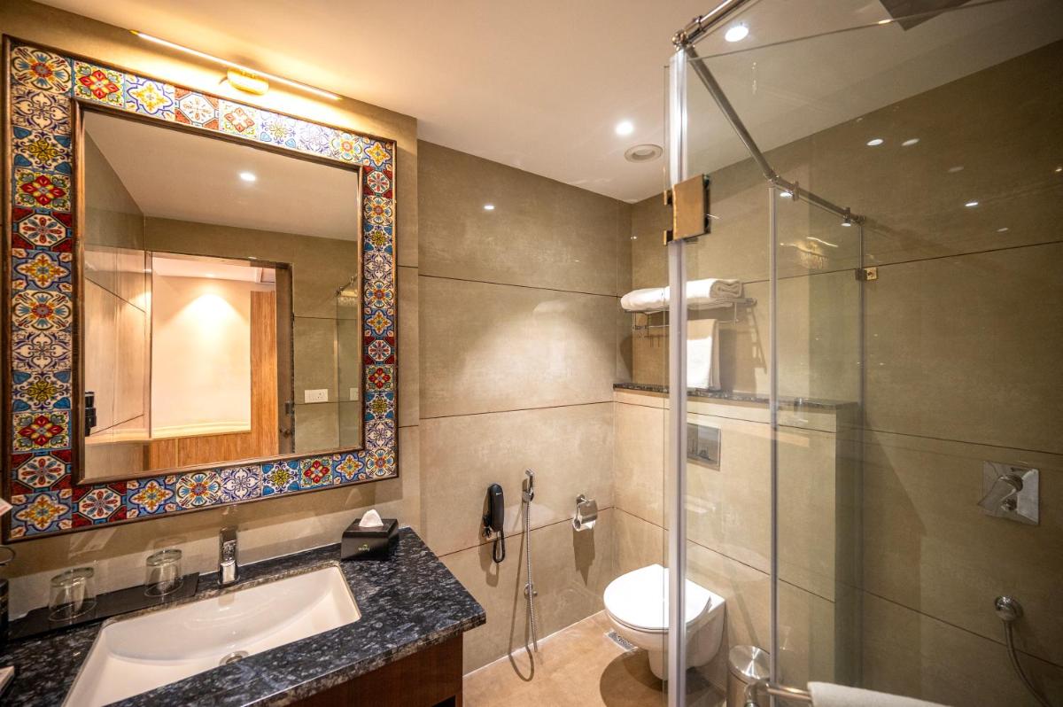 a bathroom with a shower and a sink and a toilet at Essentia Luxury Resort & Spa Udaipur in Udaipur