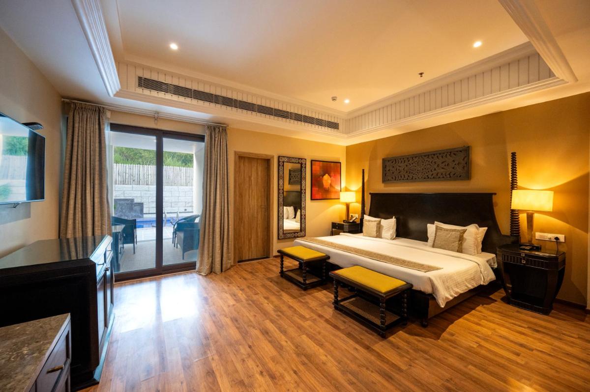 a hotel room with a bed and a television at Essentia Luxury Resort & Spa Udaipur in Udaipur