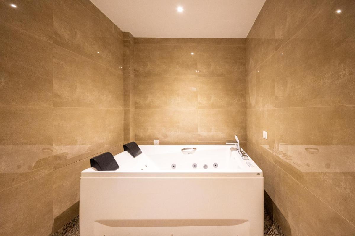 a bathroom with a tub in the corner of a room at Essentia Luxury Resort & Spa Udaipur in Udaipur