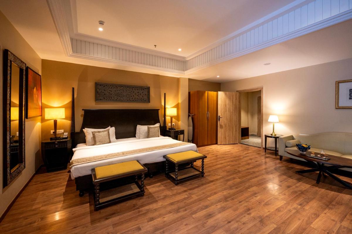 a bedroom with a large bed and two chairs at Essentia Luxury Resort & Spa Udaipur in Udaipur