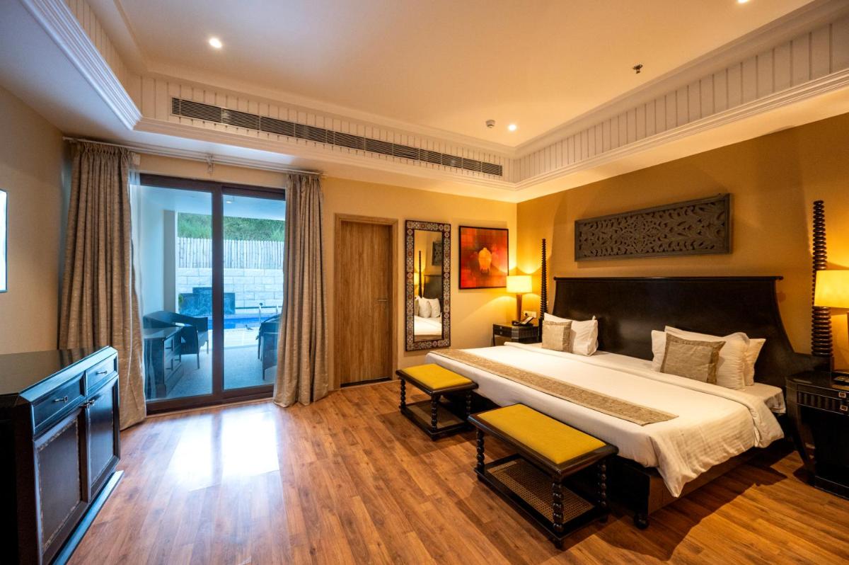 a bedroom with a large bed and a balcony at Essentia Luxury Resort & Spa Udaipur in Udaipur