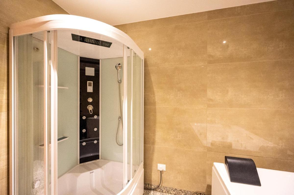 a bathroom with a shower and a mirror at Essentia Luxury Resort & Spa Udaipur in Udaipur