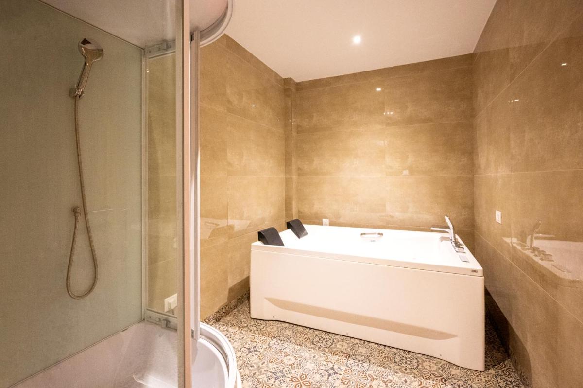 a bathroom with a tub and a shower and a toilet at Essentia Luxury Resort & Spa Udaipur in Udaipur