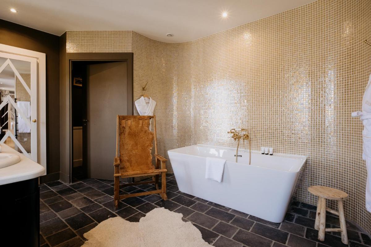 une salle de bains avec une baignoire blanche et un lavabo dans l'établissement Grand Hotel Soleil d'Or, à Megève