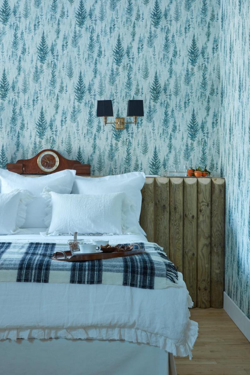 une chambre avec un lit avec un papier peint bleu et blanc dans l'établissement Grand Hotel Soleil d'Or, à Megève
