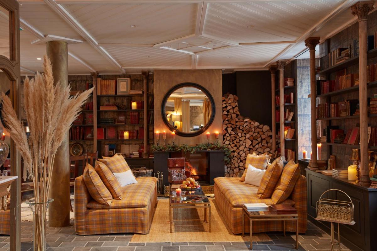 un salon avec deux canapés et un miroir dans l'établissement Grand Hotel Soleil d'Or, à Megève