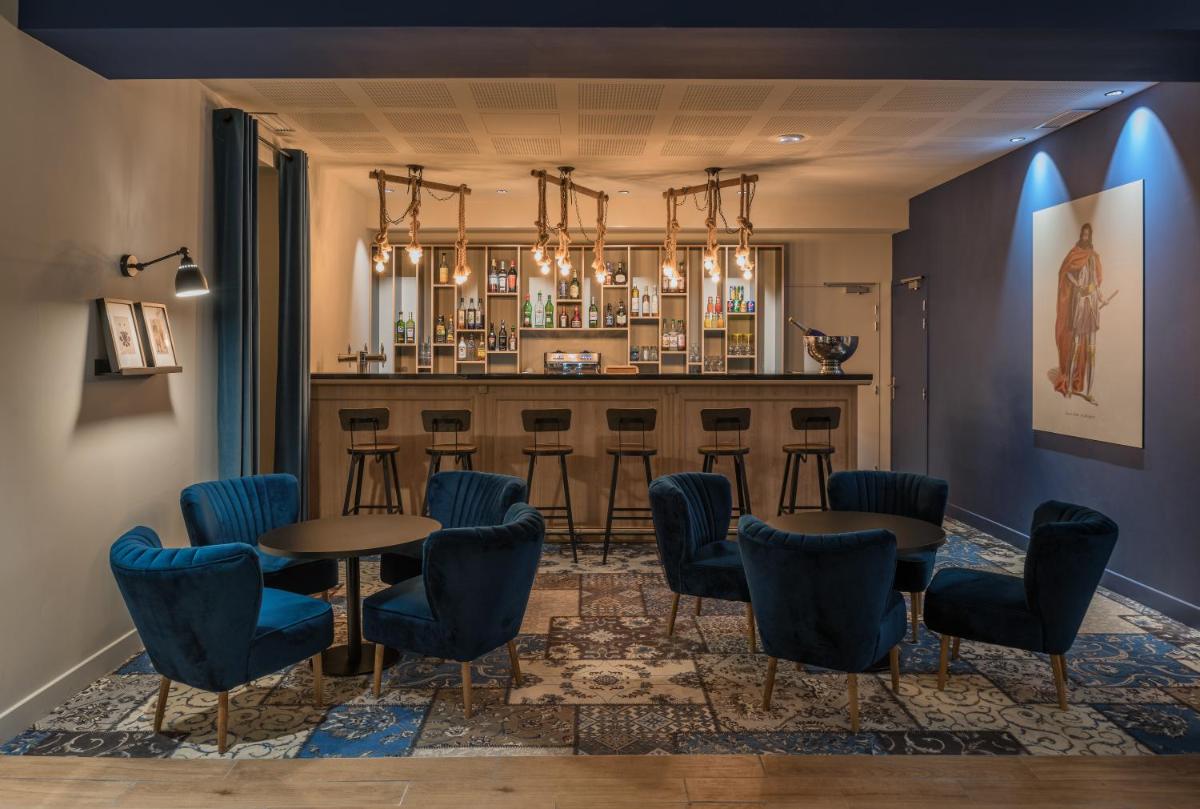un bar avec des chaises et des tables bleues dans une pièce dans l'établissement SOWELL HOTELS Les Chevaliers, à Carcassonne
