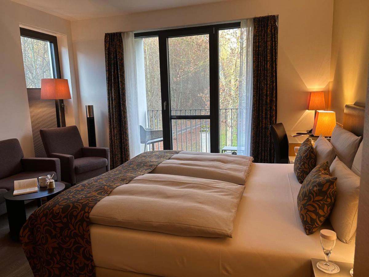 ein Schlafzimmer mit einem großen Bett und einem großen Fenster in der Unterkunft Schlossgut Gross Schwansee in Groß Schwansee