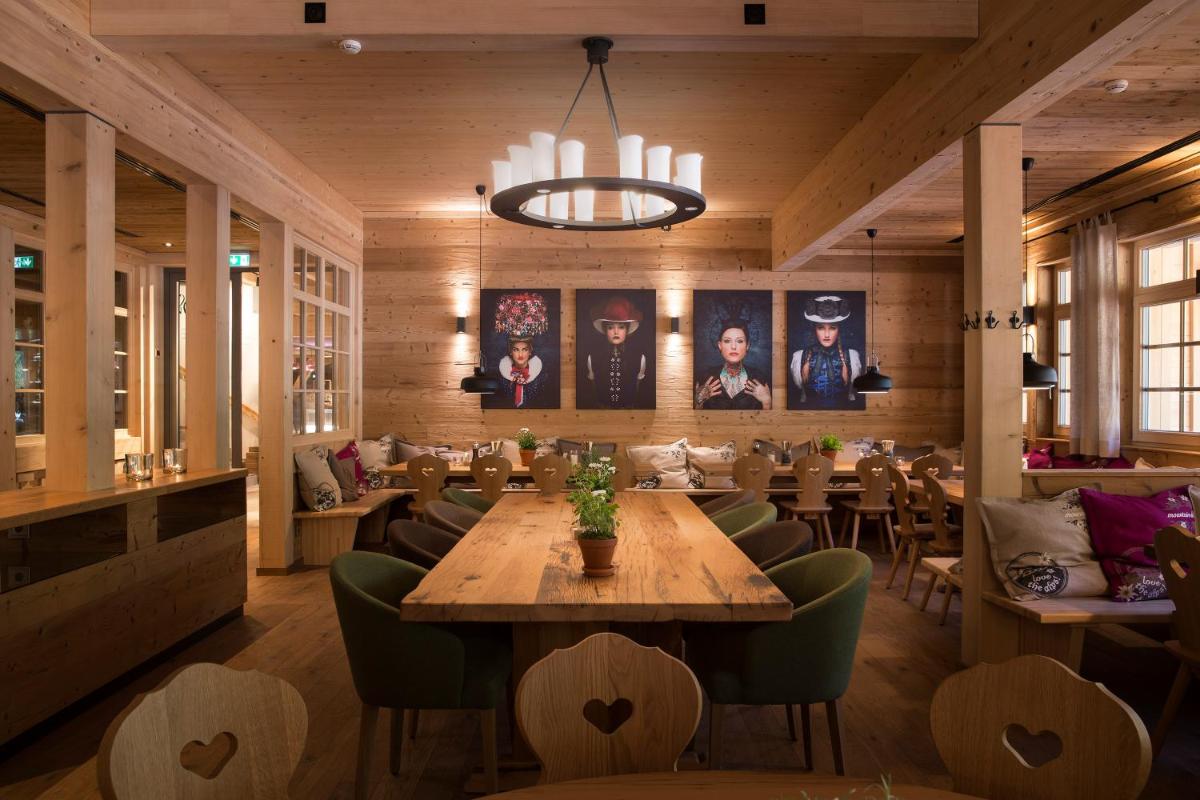 ein Restaurant mit einem großen Holztisch und Stühlen in der Unterkunft Gästehaus der Geroldsauer Mühle in Baden-Baden + 30 Fotos