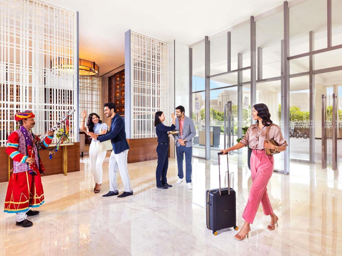 a group of people standing in a lobby at Novotel Jaipur Convention Centre in Jaipur