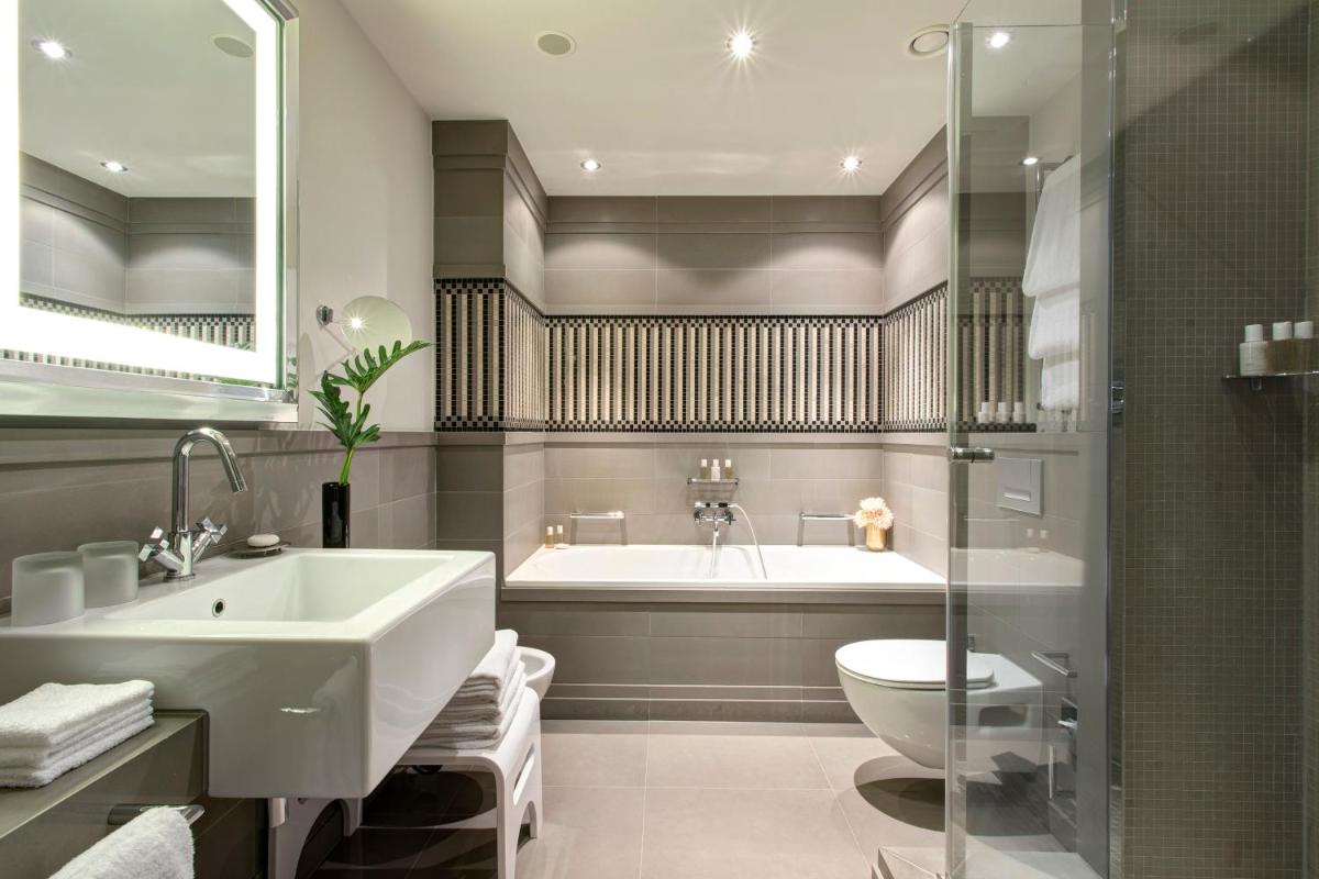 ein Badezimmer mit Badewanne, Waschbecken und Toilette in der Unterkunft Hotel De Rome Berlin in Berlin