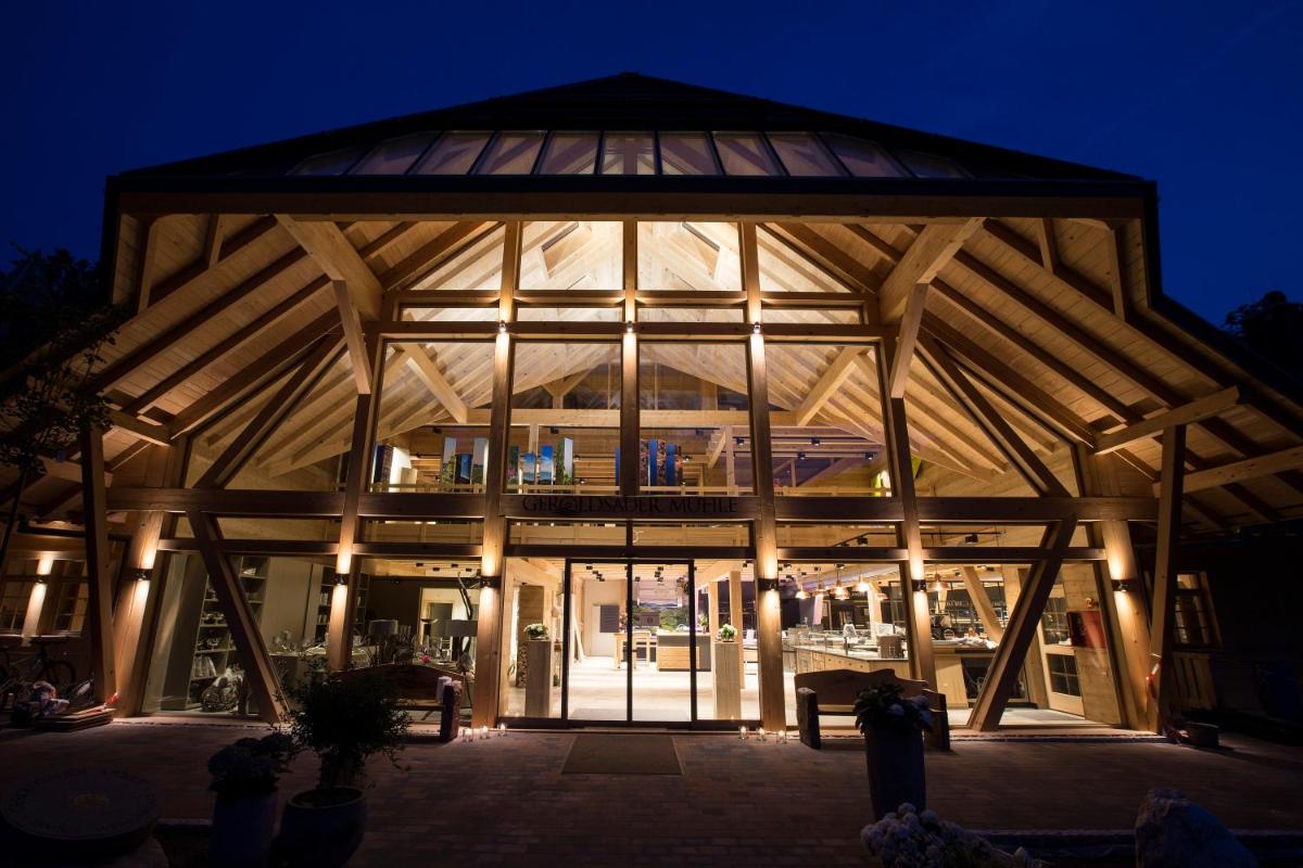 ein großes Gebäude mit einem großen Glasfenster in der Nacht in der Unterkunft Gästehaus der Geroldsauer Mühle in Baden-Baden