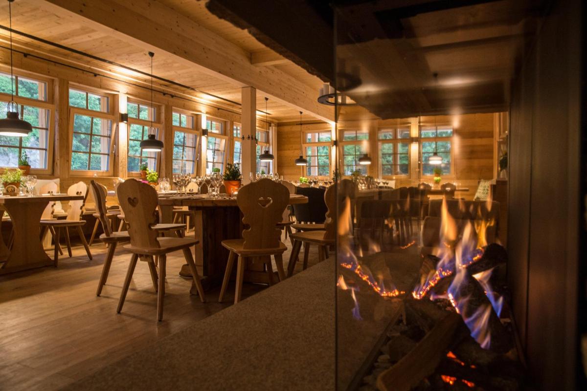 ein Restaurant mit einem Kamin sowie Tischen und Stühlen in der Unterkunft Gästehaus der Geroldsauer Mühle in Baden-Baden