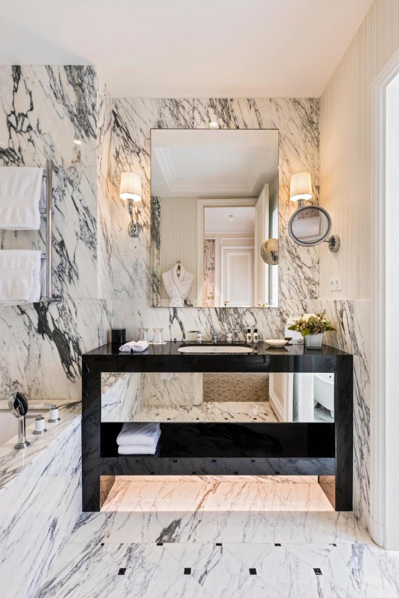 une salle de bains avec un grand miroir et un lavabo dans l'établissement Hôtel San Régis, à Paris