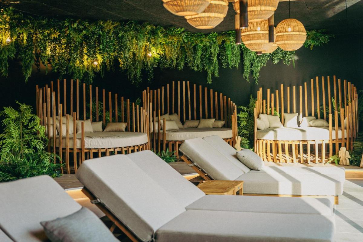 une pièce avec des canapés blancs, des plantes et des lumières dans l'établissement Best Western Plus Le Roi Arthur Hôtel & Spa, à Ploërmel