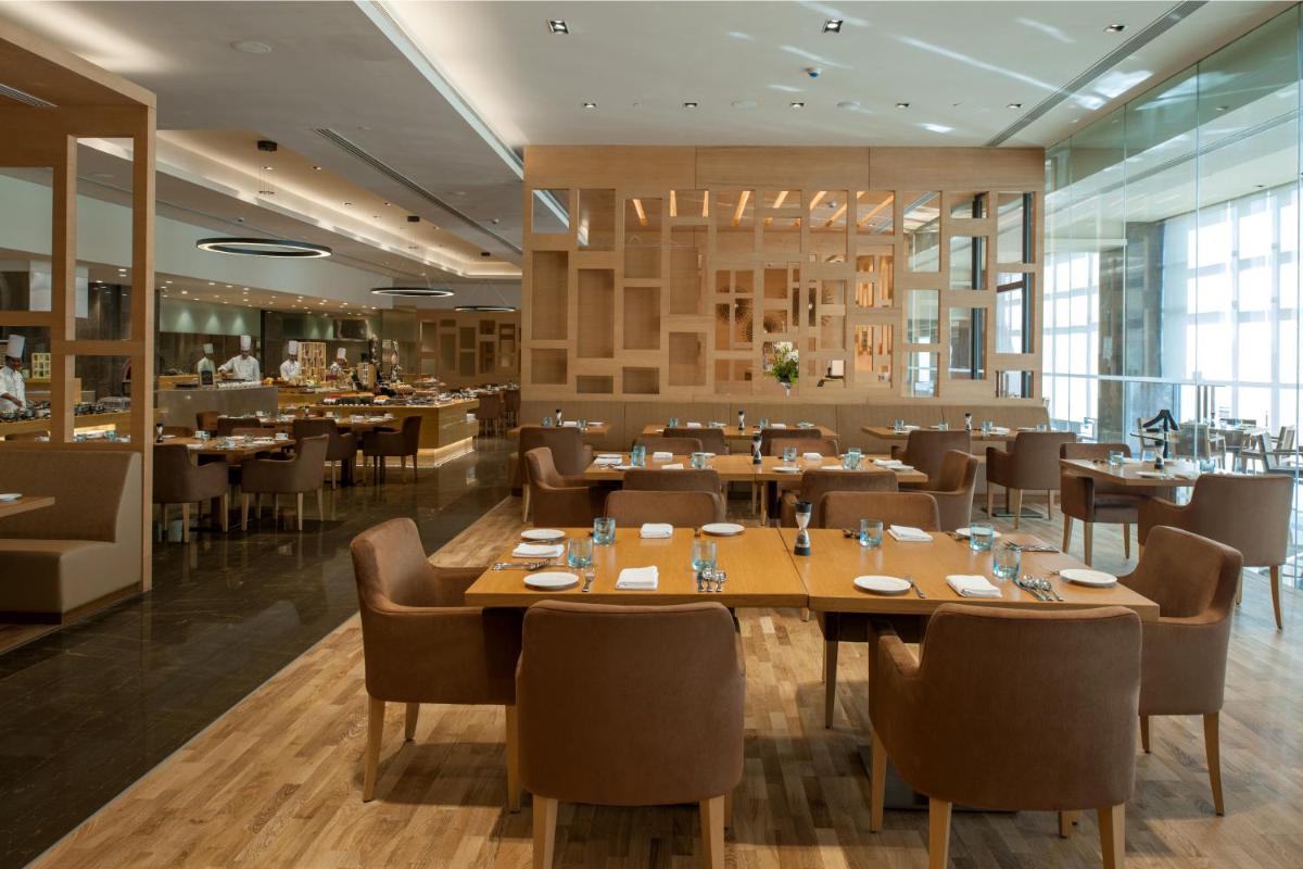 a dining room with tables and chairs and a restaurant at Feathers- A Radha Hotel, Chennai in Chennai