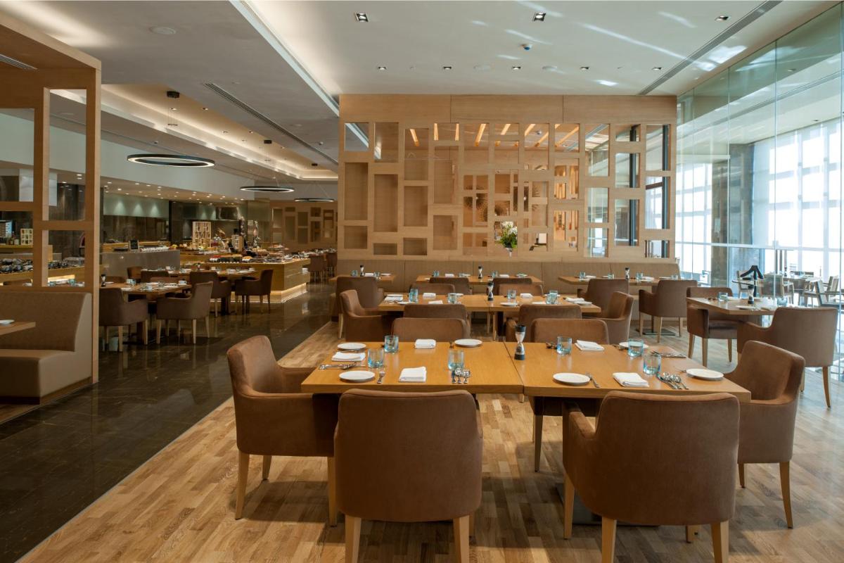 a dining room with tables and chairs and a restaurant at Feathers- A Radha Hotel, Chennai in Chennai