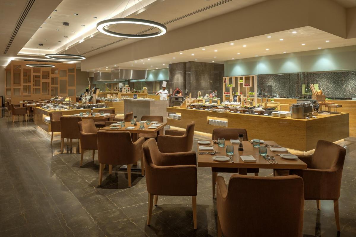 a restaurant with tables and chairs and a bar at Feathers- A Radha Hotel, Chennai in Chennai