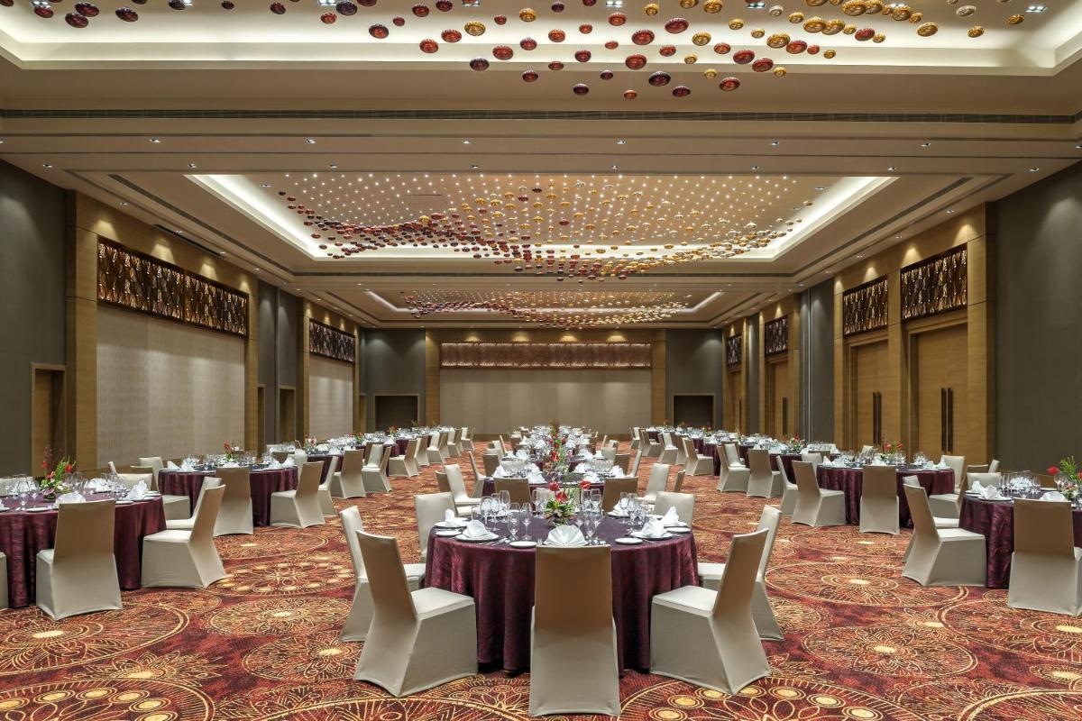 a large banquet hall with tables and chairs at Feathers- A Radha Hotel, Chennai in Chennai