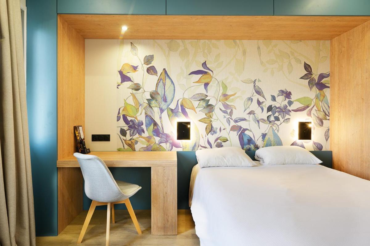 une chambre avec un lit, une table et une chaise dans l'établissement Hotel Du Commerce Spa, à Saint-Gaudens