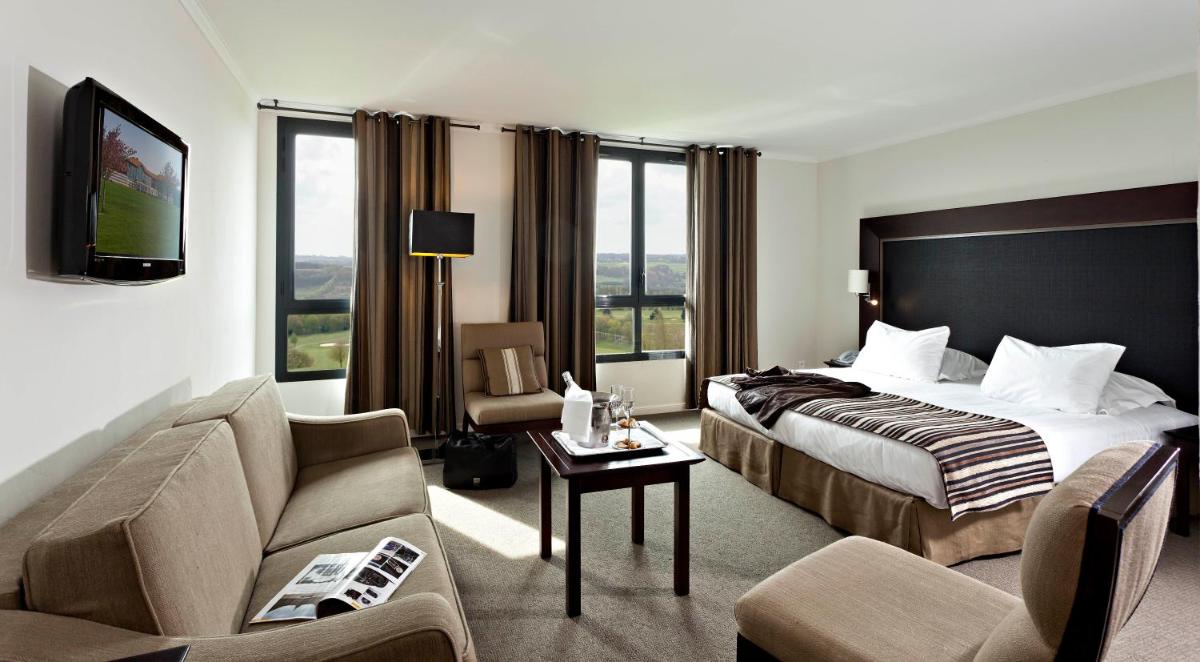 une chambre d'hôtel avec un lit et un canapé dans l'établissement Hôtel du Golf, à Lumbres 22 autres photos