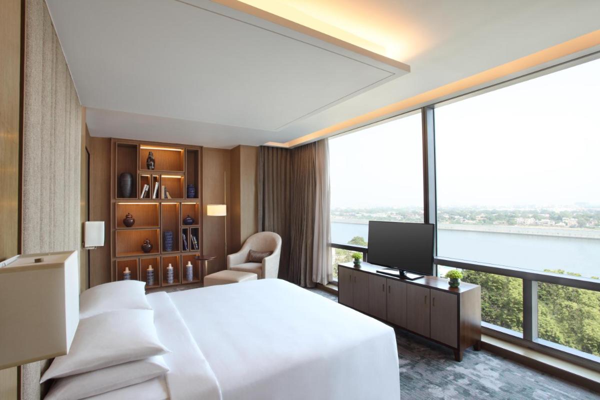 a hotel room with a bed and a large window at Hyatt Regency Ahmedabad in Ahmedabad