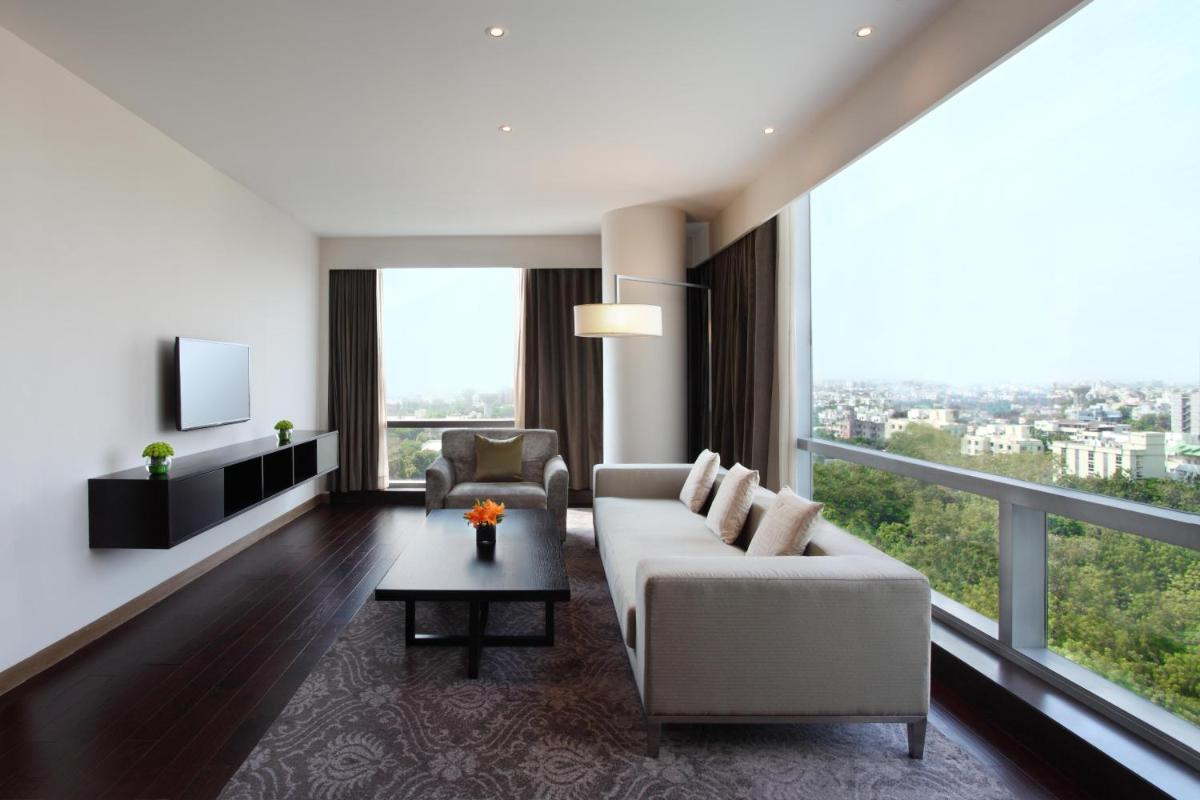 a living room with a white couch and a large window at Hyatt Regency Ahmedabad in Ahmedabad