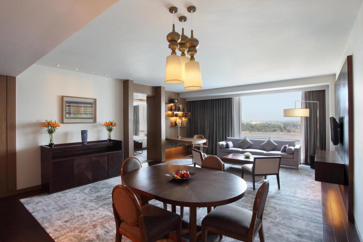 a living room with a table and chairs and a couch at Hyatt Regency Ahmedabad in Ahmedabad