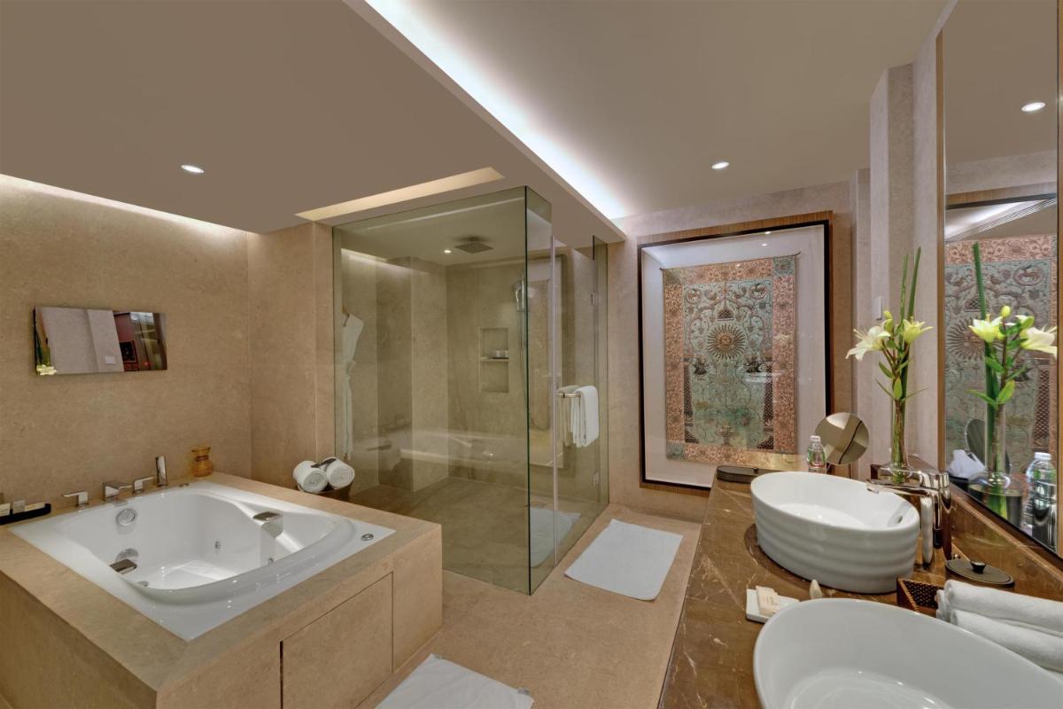 a bathroom with a tub and a shower and a sink at Hyatt Regency Ahmedabad in Ahmedabad