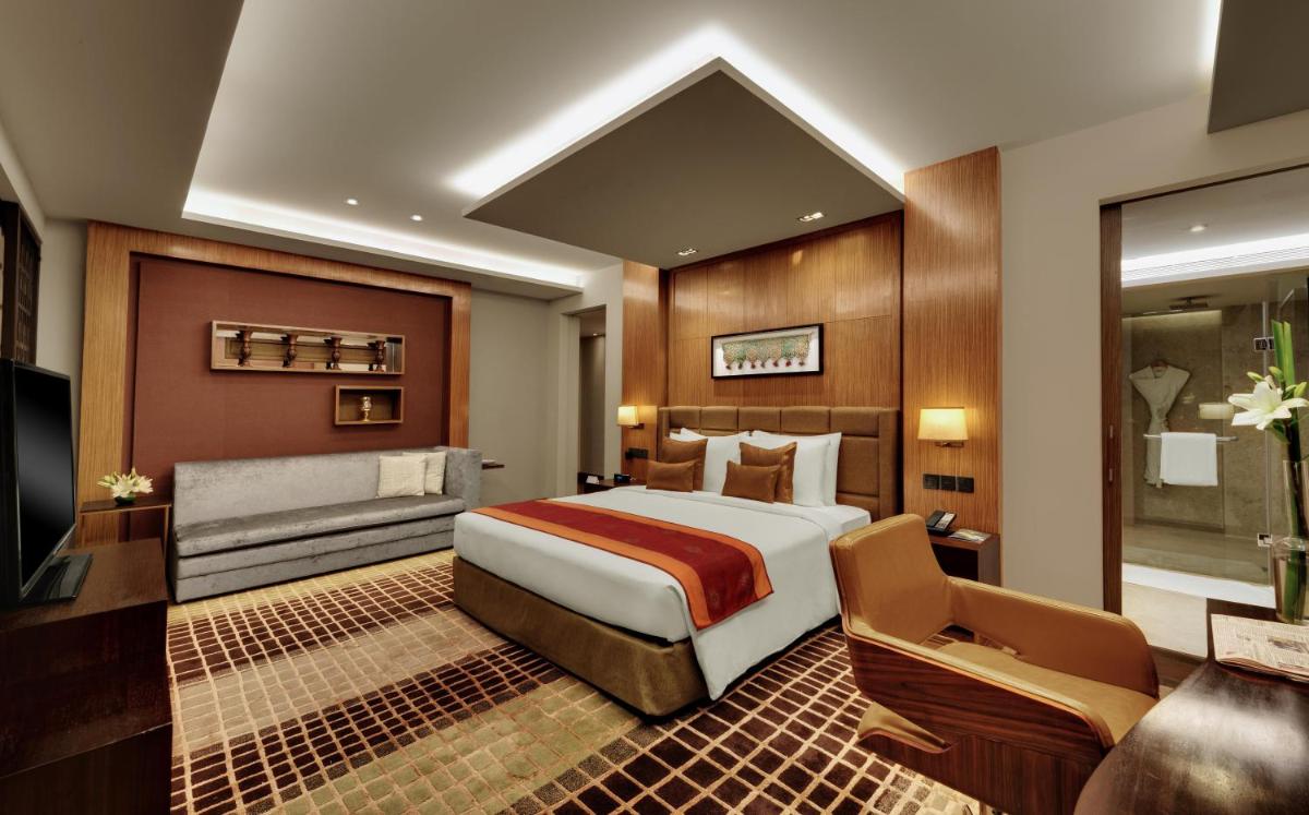 a hotel room with a bed and a couch at Hyatt Regency Ahmedabad in Ahmedabad