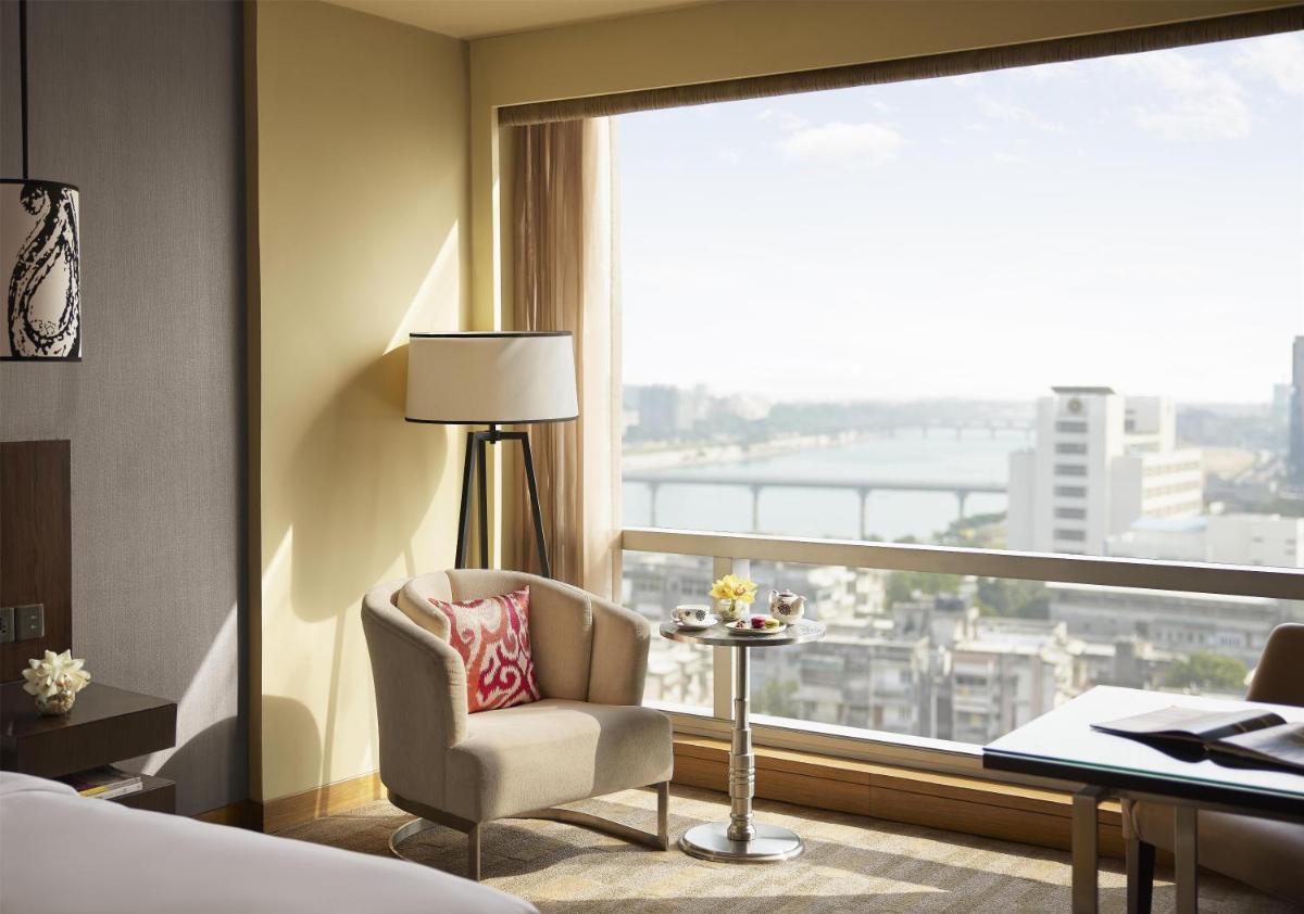 a hotel room with a chair and a large window at Hyatt Regency Ahmedabad in Ahmedabad