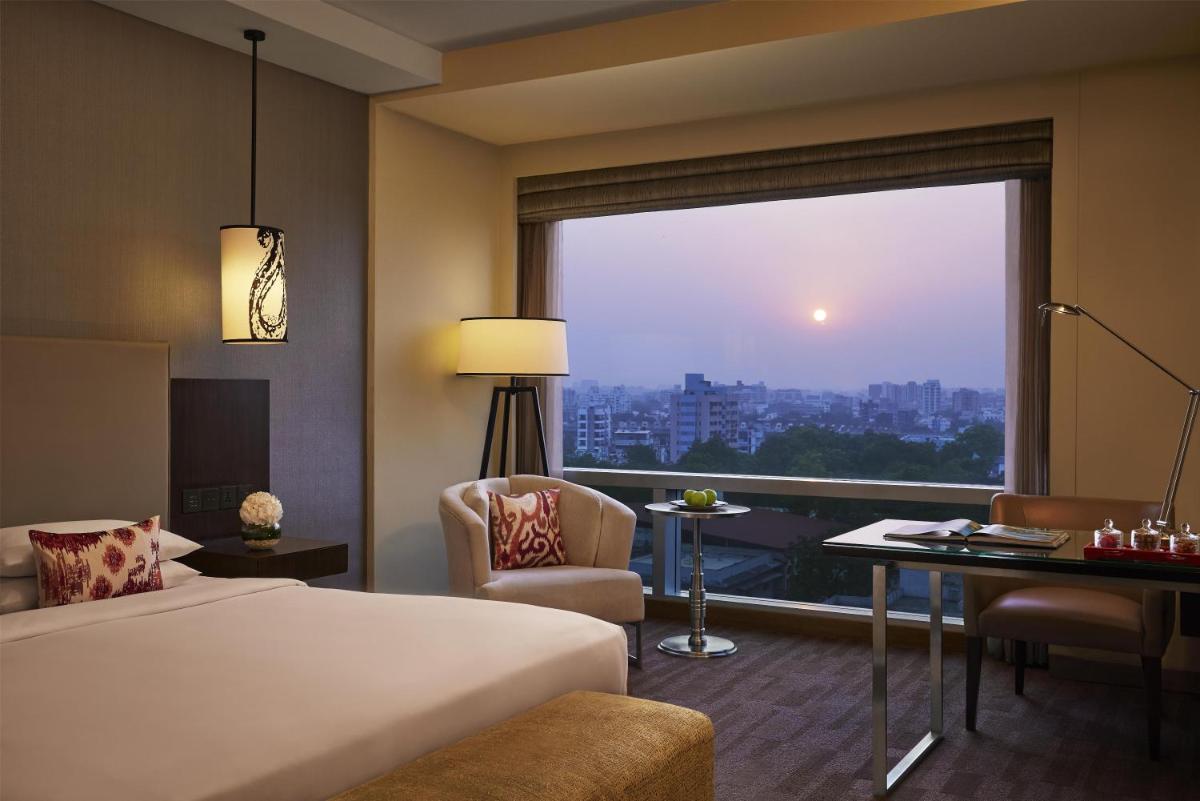 a hotel room with a bed and a large window at Hyatt Regency Ahmedabad in Ahmedabad